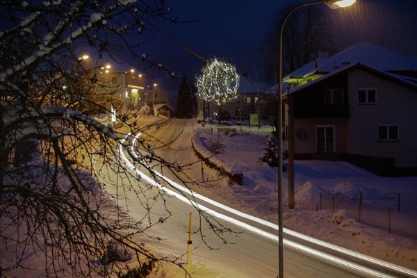 Eine verschneite Straße mit Häusern und Bäumen